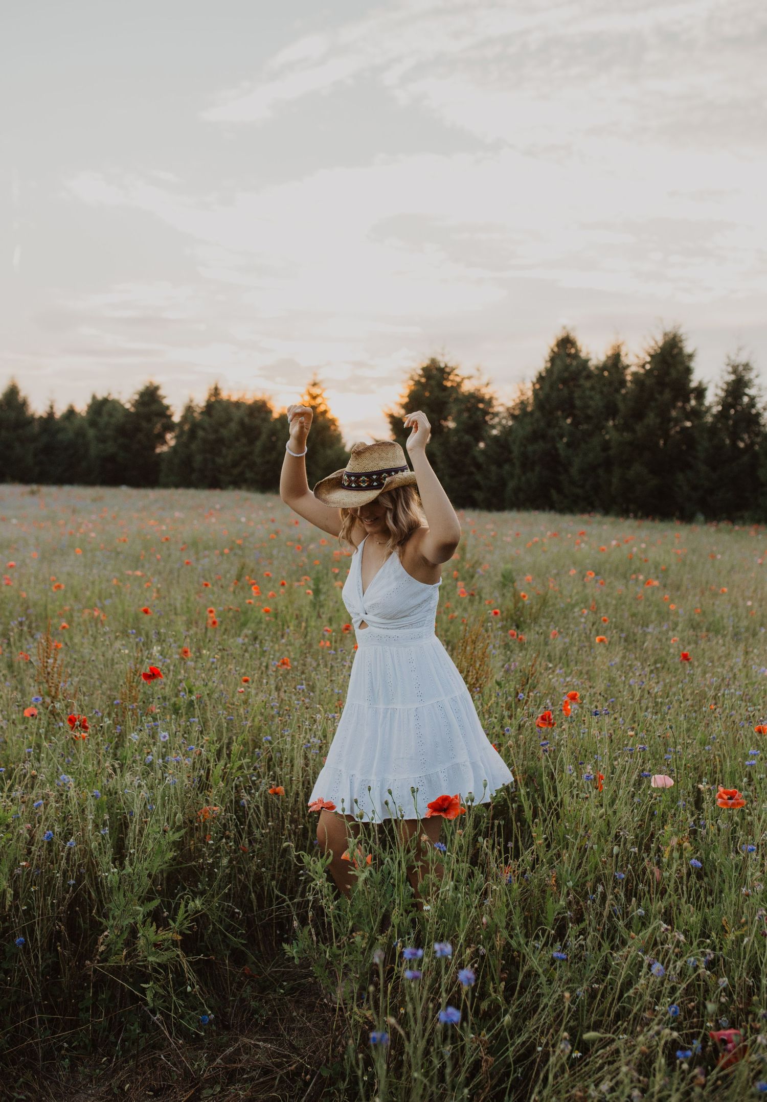 Dancing through a summer meadow filled with red poppies and purple wildflowers.