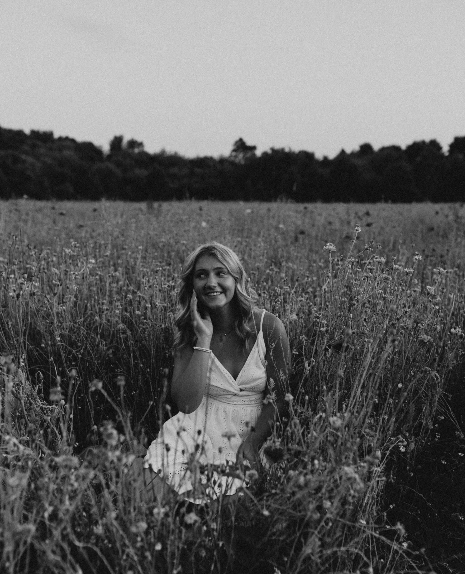 Black and white portrait composition in a wildflower meadow with soft natural lighting.