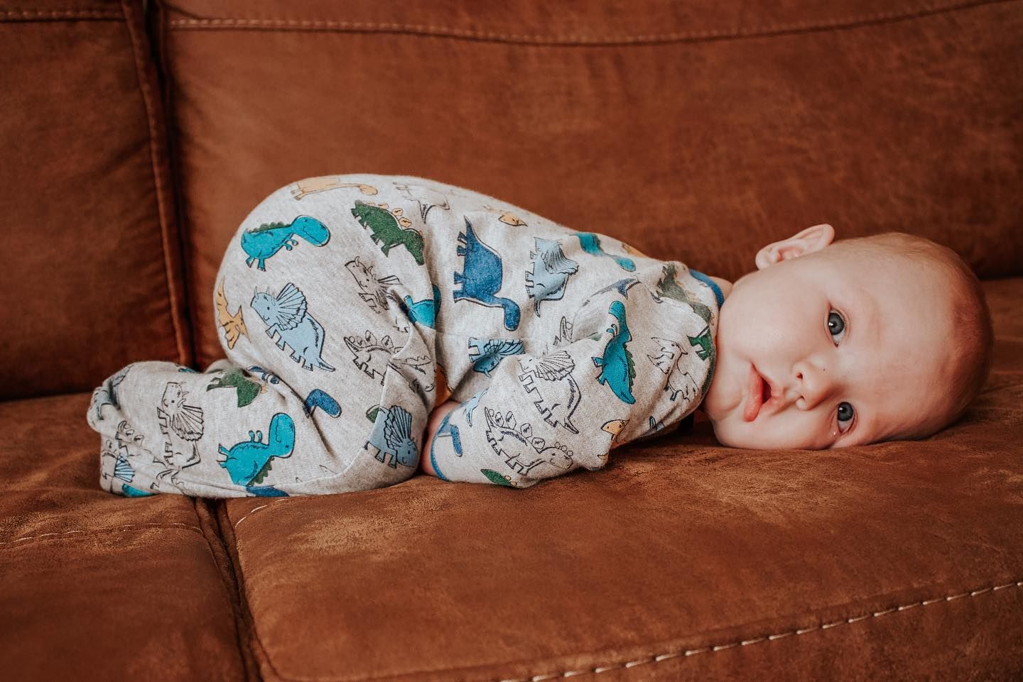 A baby laying peacefully on a brown leather couch in a collage-style photo series.| Westminster, CO motherhood & family photographer