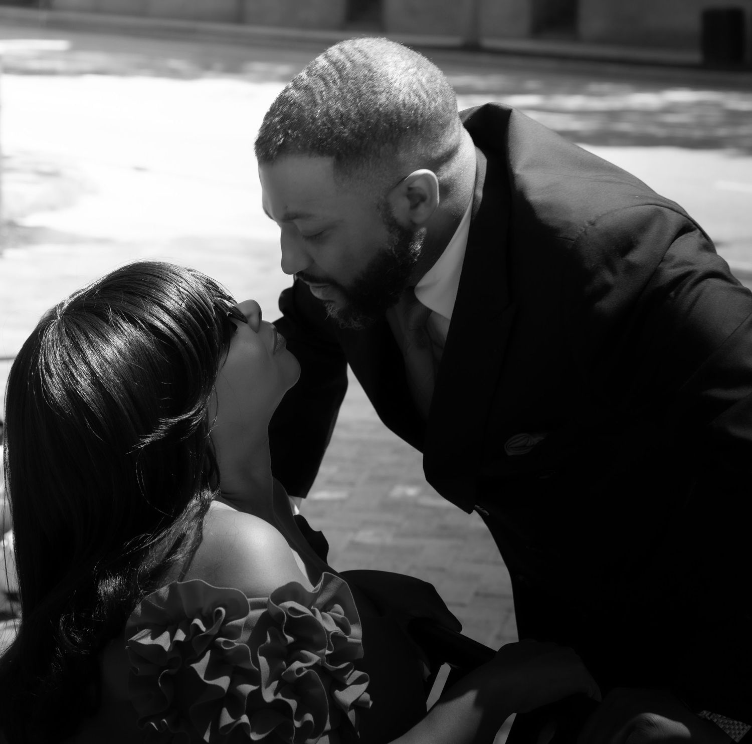 Black and white romantic photo showing a tender intimate moment between a couple in formal attire.