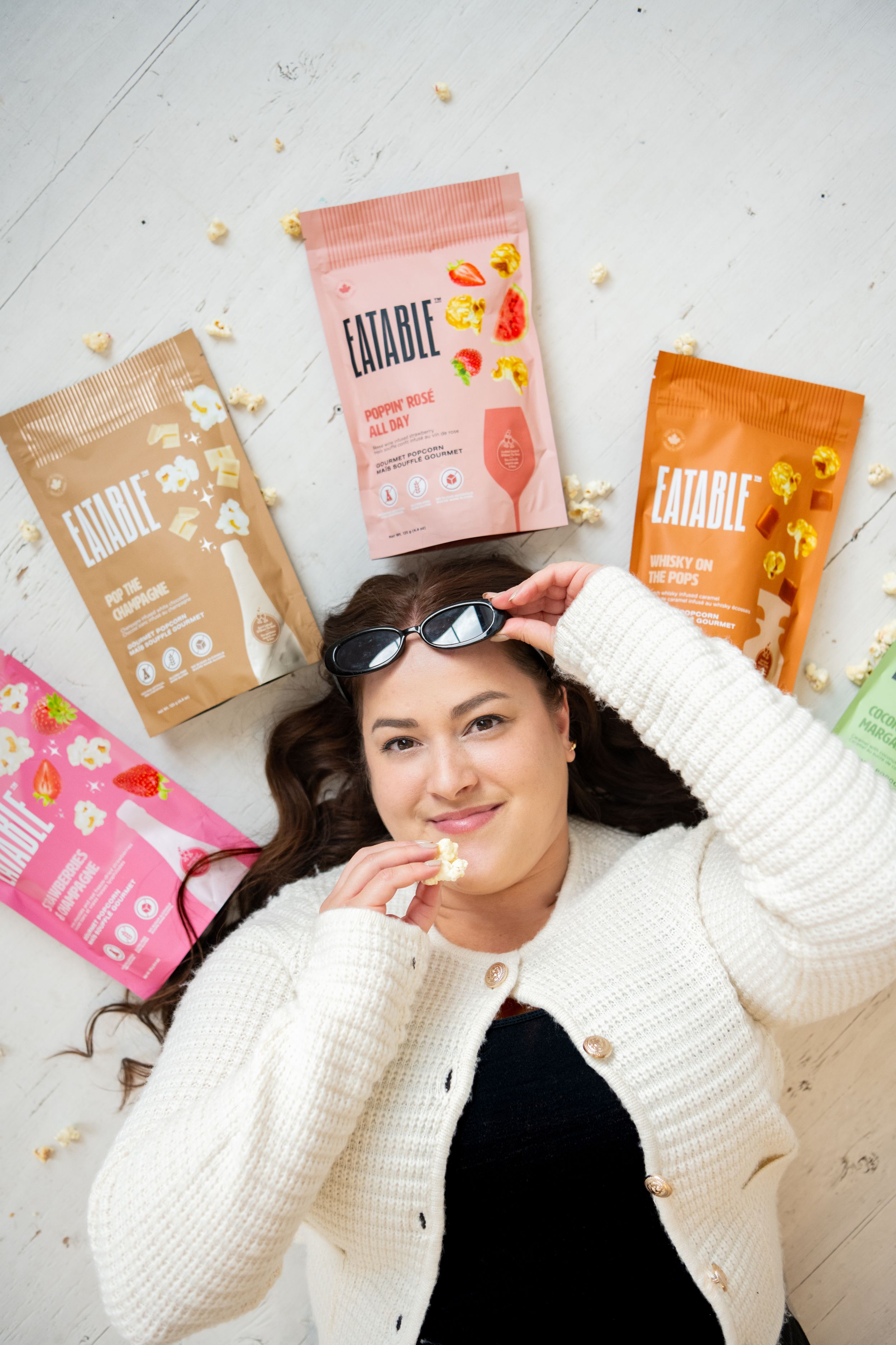 Colorful snack food packages arranged artistically on a white surface with lifestyle product photography.