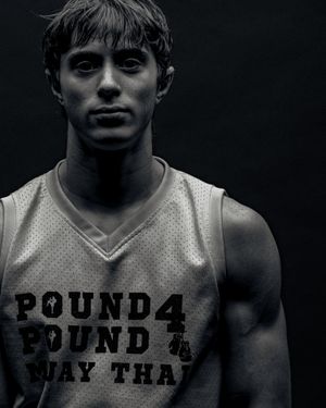 Black and white dramatic portrait of an athlete wearing a white basketball jersey with text 'Pound 4 Pound' printed on it.