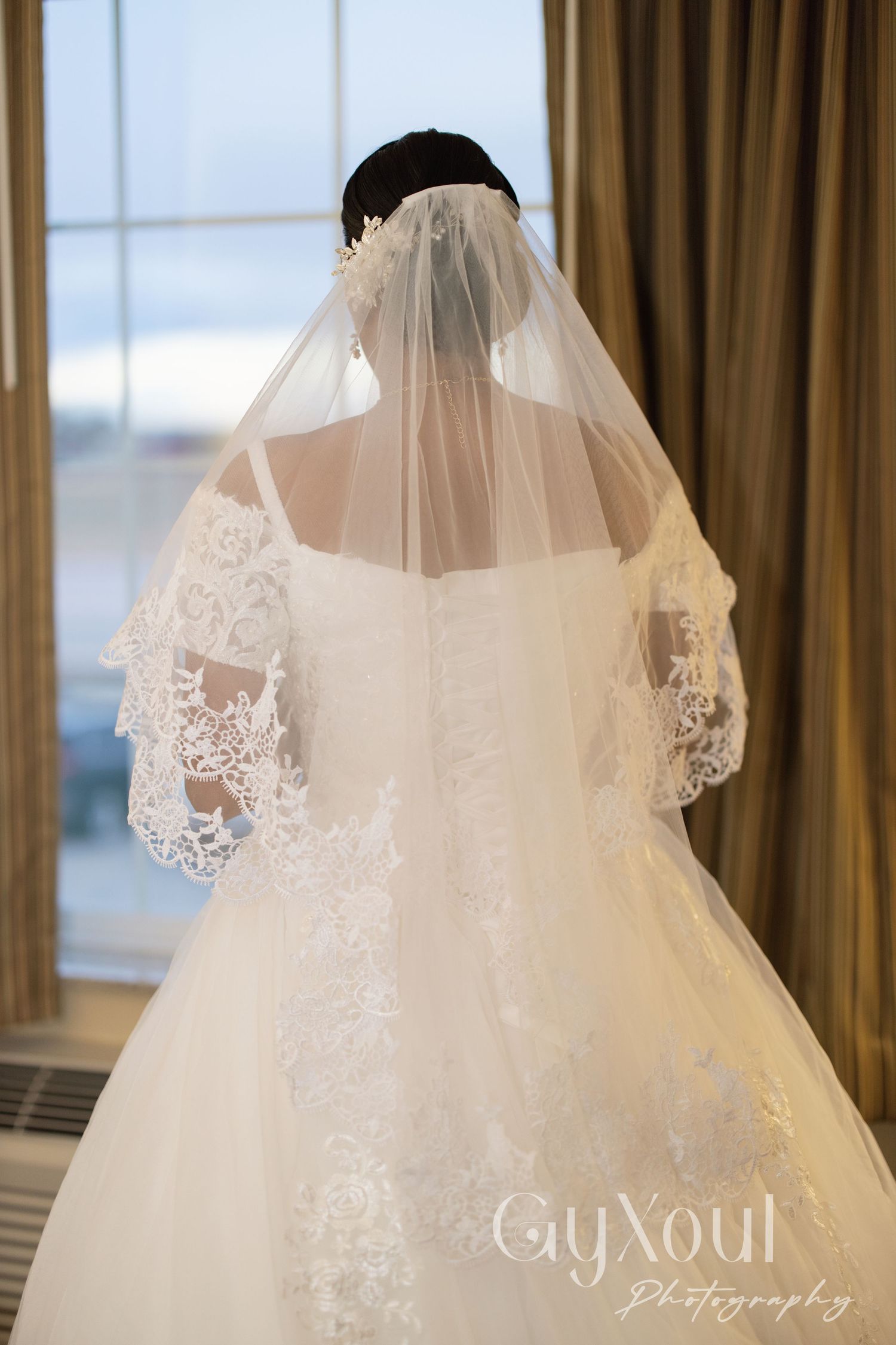 Back view of wedding dress showing intricate lace veil details.