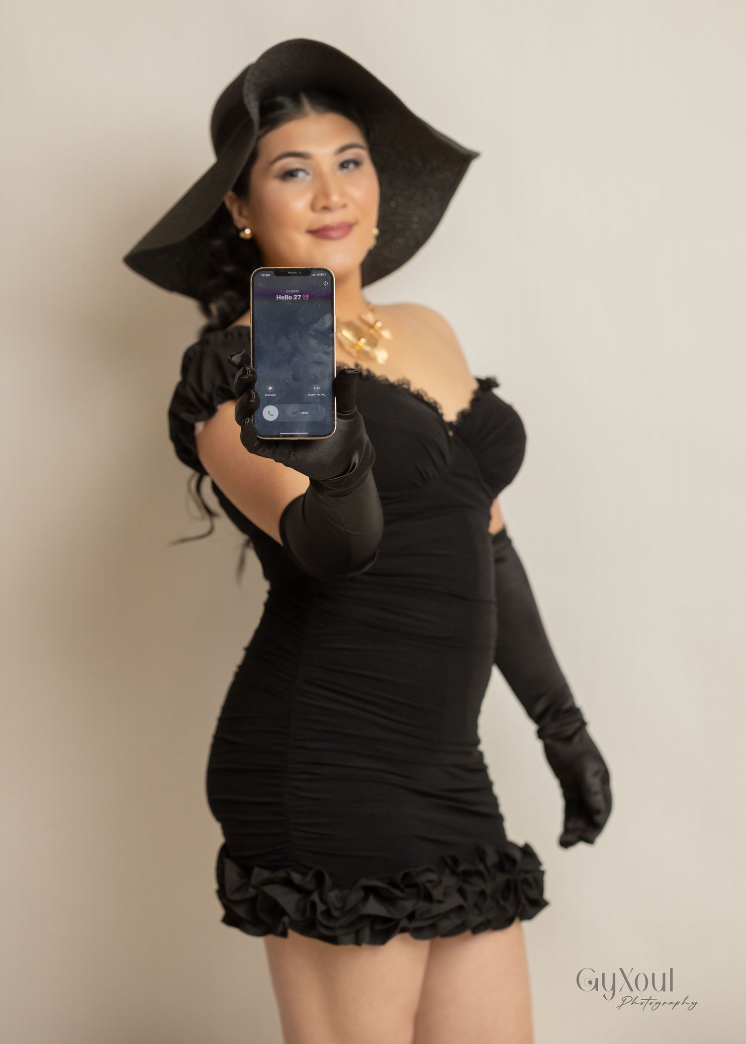 Glamorous Vintage-inspired birthday photoshoot featuring a black ruched dress, long gloves, and wide-brimmed hat with a phone selfie pose.