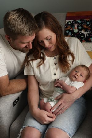 An intimate indoor family moment captured in soft lighting on a couch.