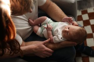 Intimate close-up shots of tender family moments in moody lighting.