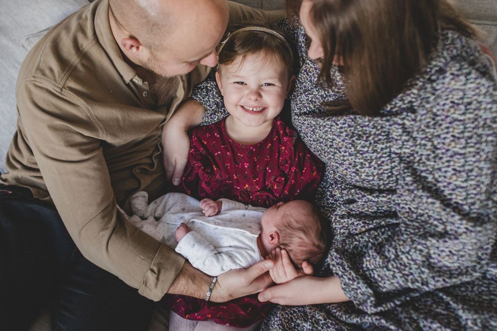 A heartwarming family moment as siblings bond during a tender indoor photoshoot.