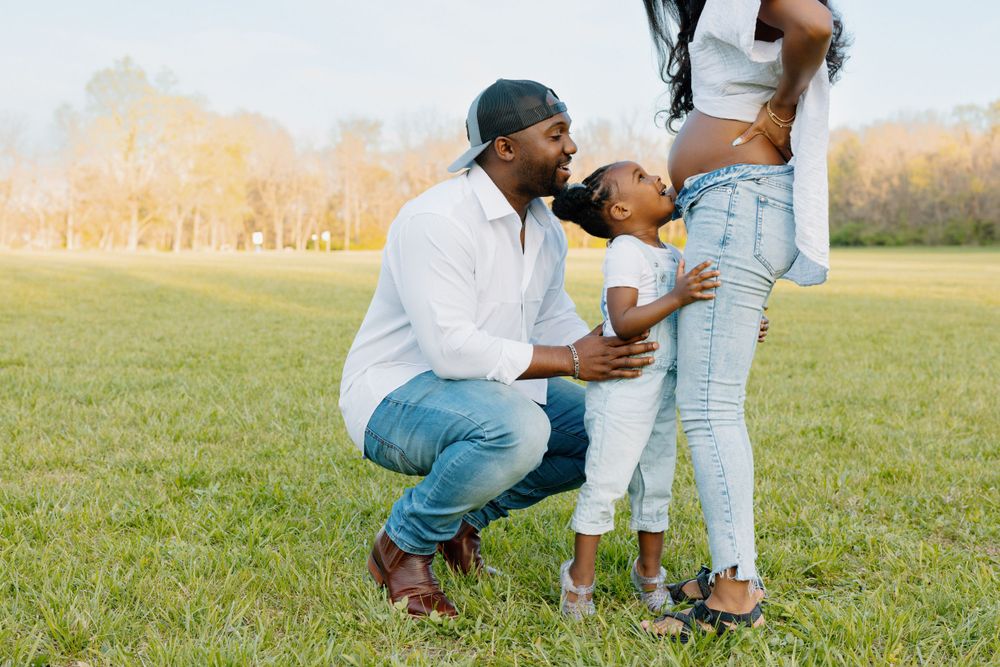 A heartwarming moment between family members in a grassy field during golden hour.