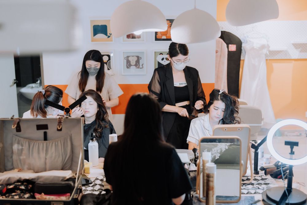 Fashion workshop with long-haired mannequin heads on display in a bright white studio interior.
