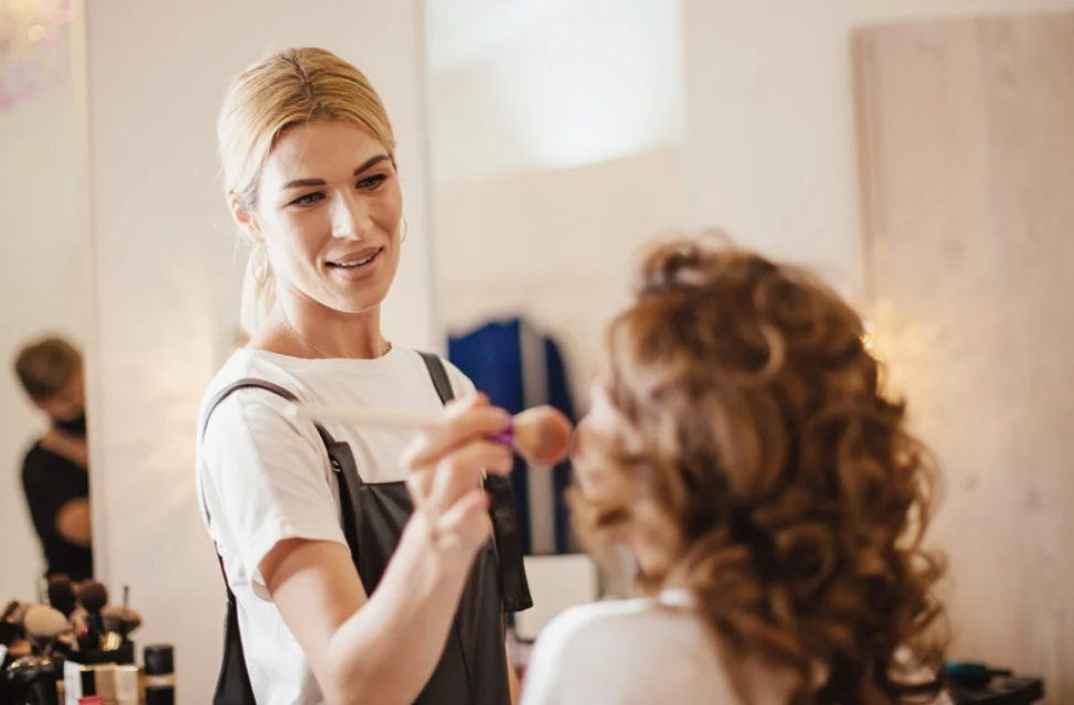 Professional hairstylist working on client's curly hair during a salon appointment.