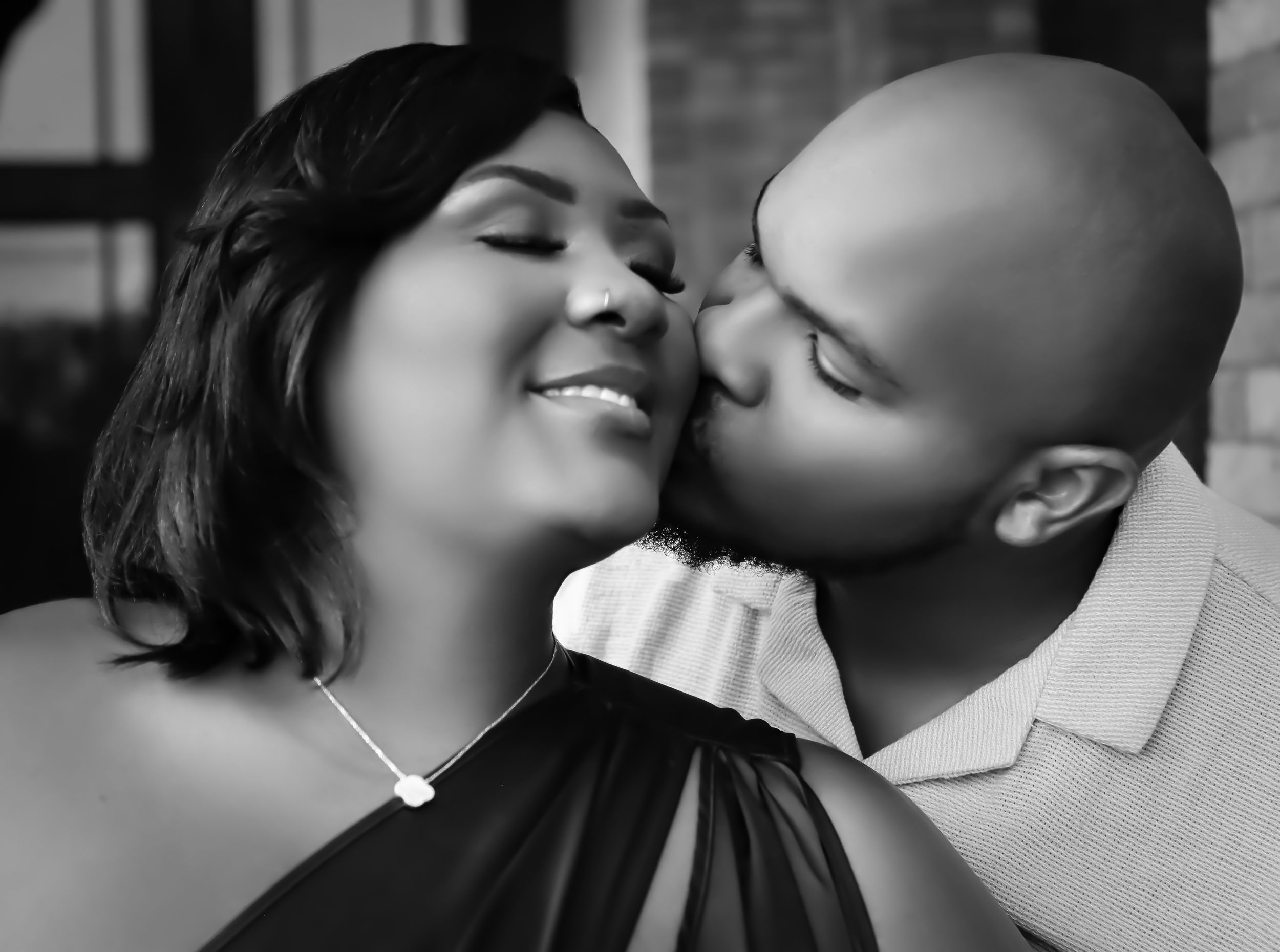 Black and white romantic portrait of a couple sharing an intimate moment with their eyes closed.
