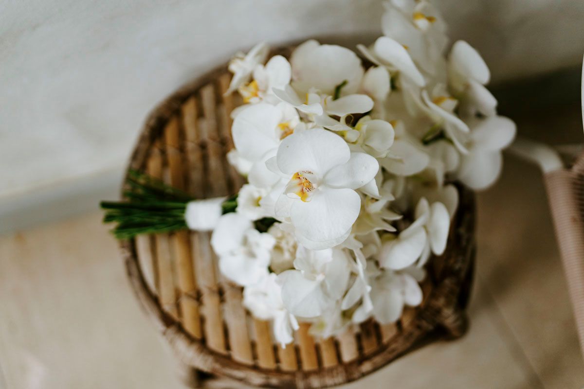 Delicate white orchid arrangements displayed in woven baskets as a details photos in Nosara
