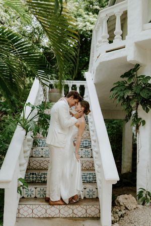 Wedding couple hugging in lush tropical gardens in Nosara surrounded by tropical greenery.