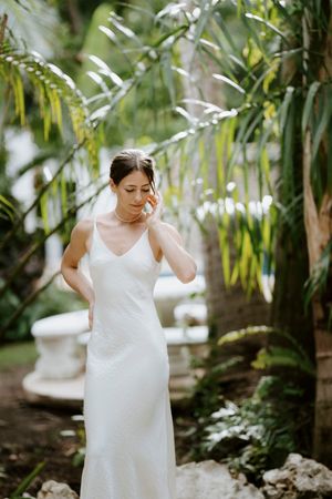 Bride adjusting her earring captured in gentle natural light at Nosara boutique hotel