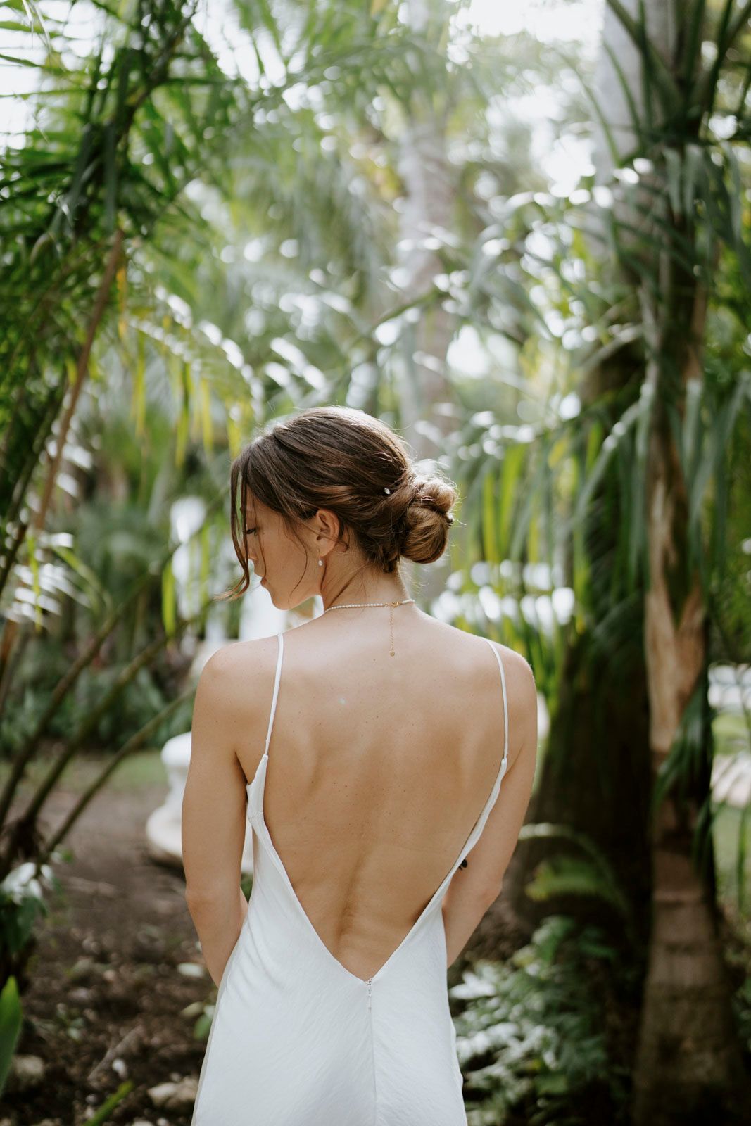 Artistic bridal portrait framed by palm leaves at boutique hotel in Nosara