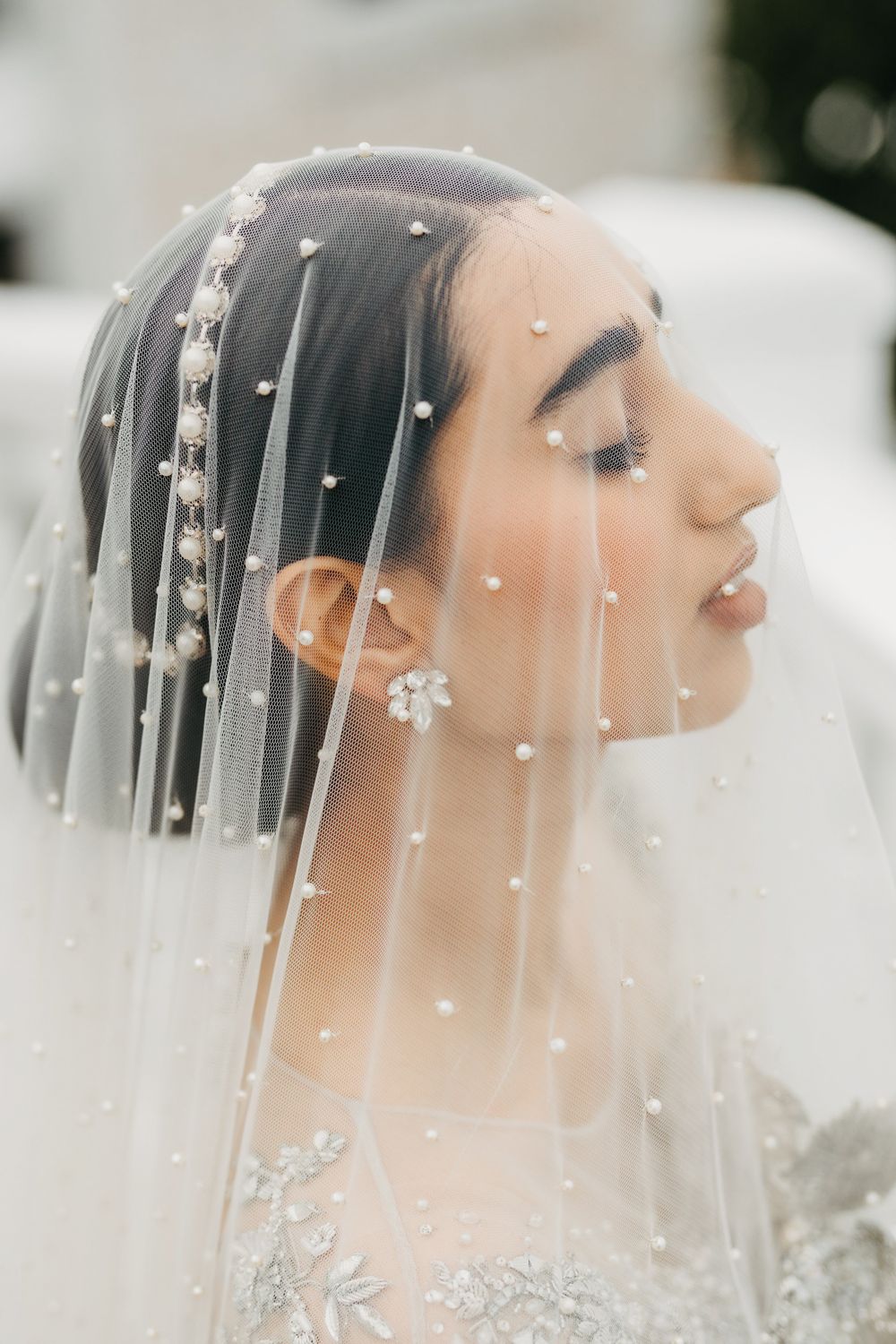 Close-up of an elegant bridal veil with pearl accents and delicate embroidery details.