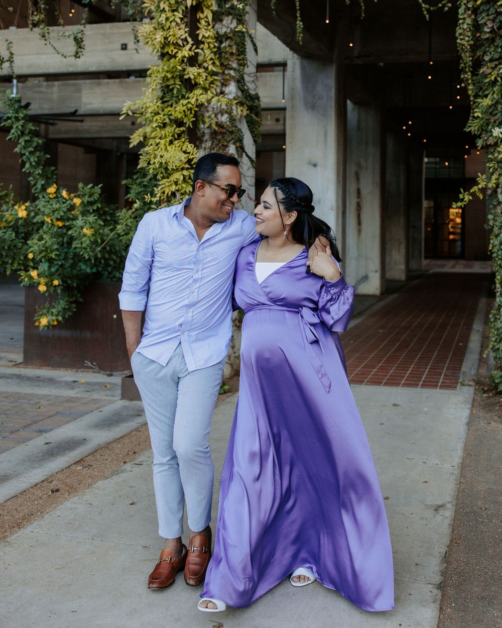 San Antonio Maternity Photography. A couple in light blue and purple attire poses against a garden backdrop.