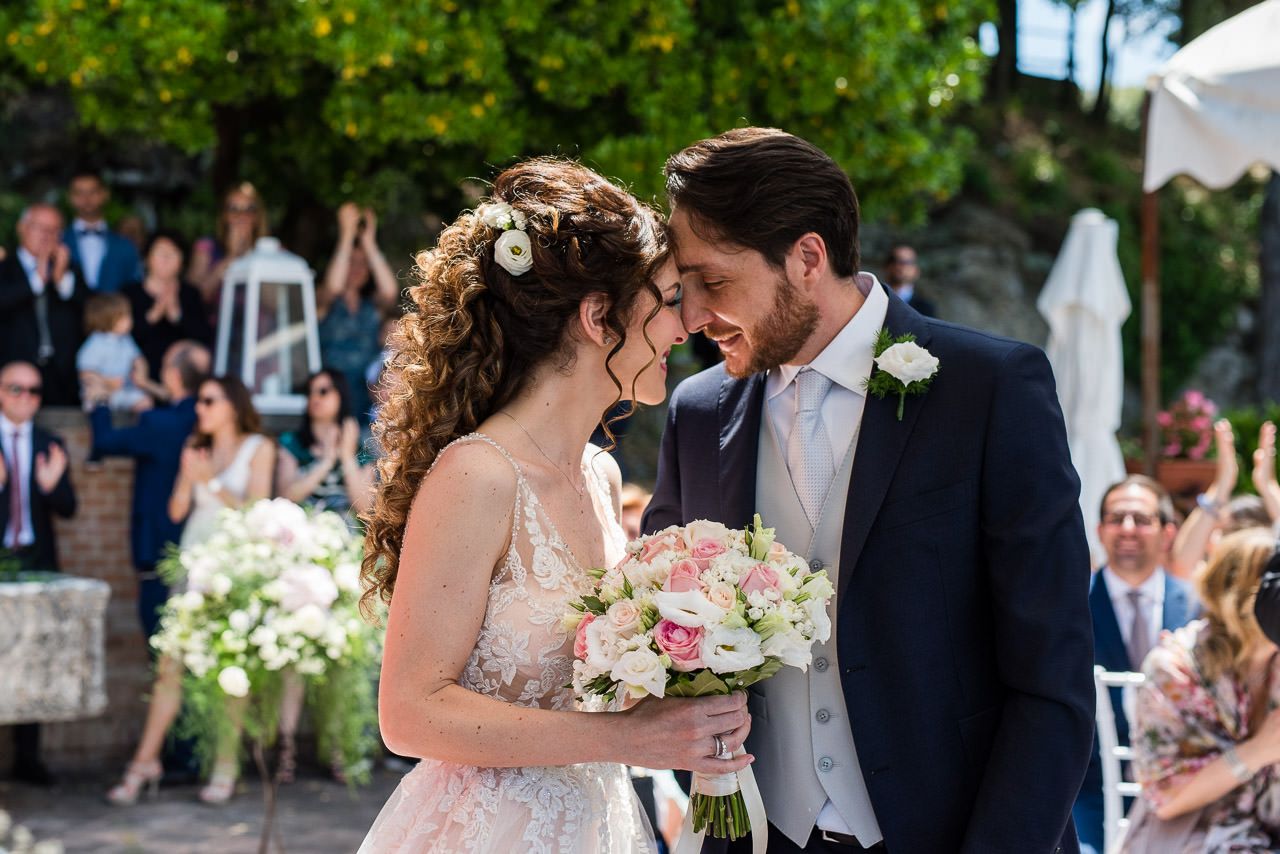 Wedding ceremony moments captured in a garden setting with natural greenery and flowers.