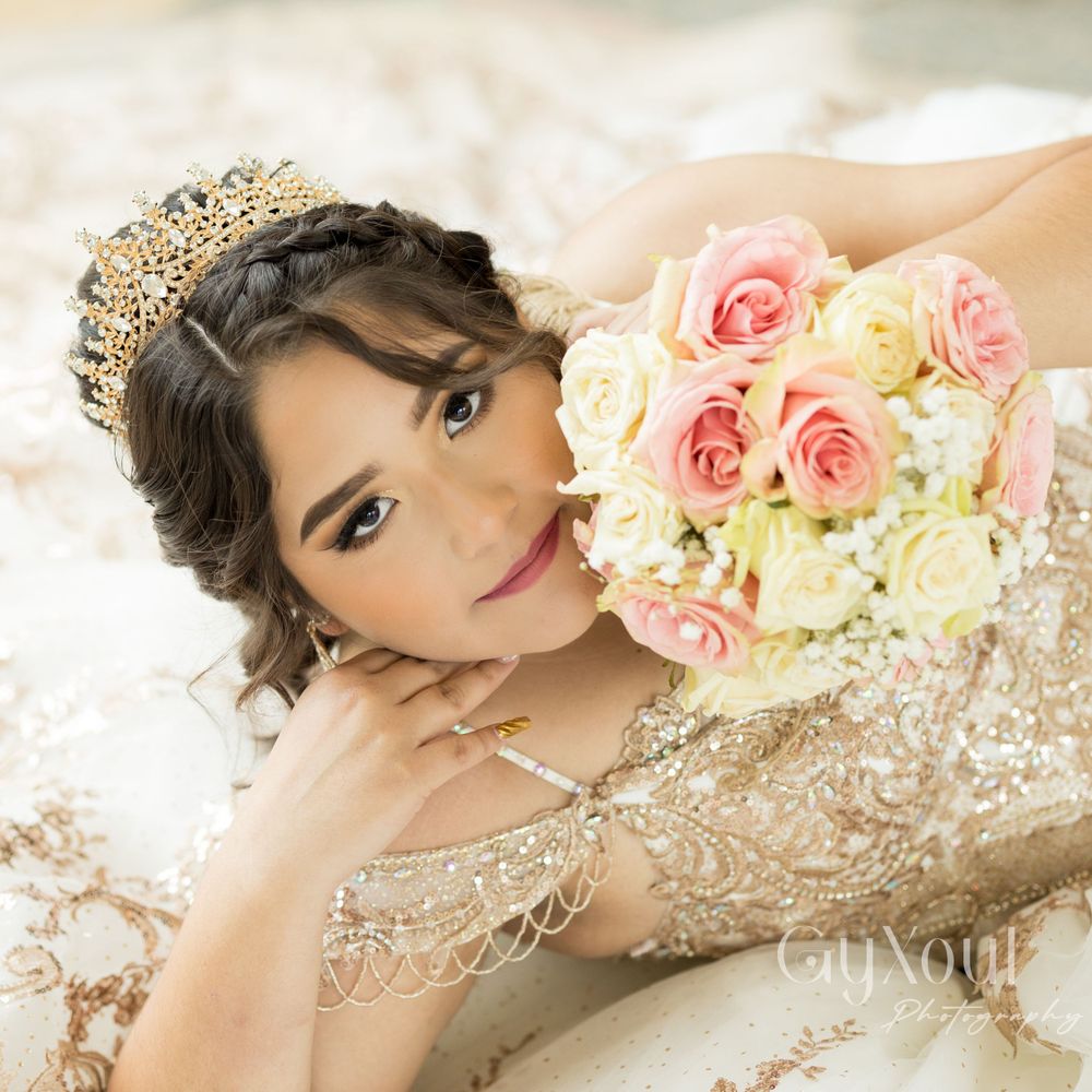 A close-up portrait with pink roses showing intricate beadwork and a golden crown.