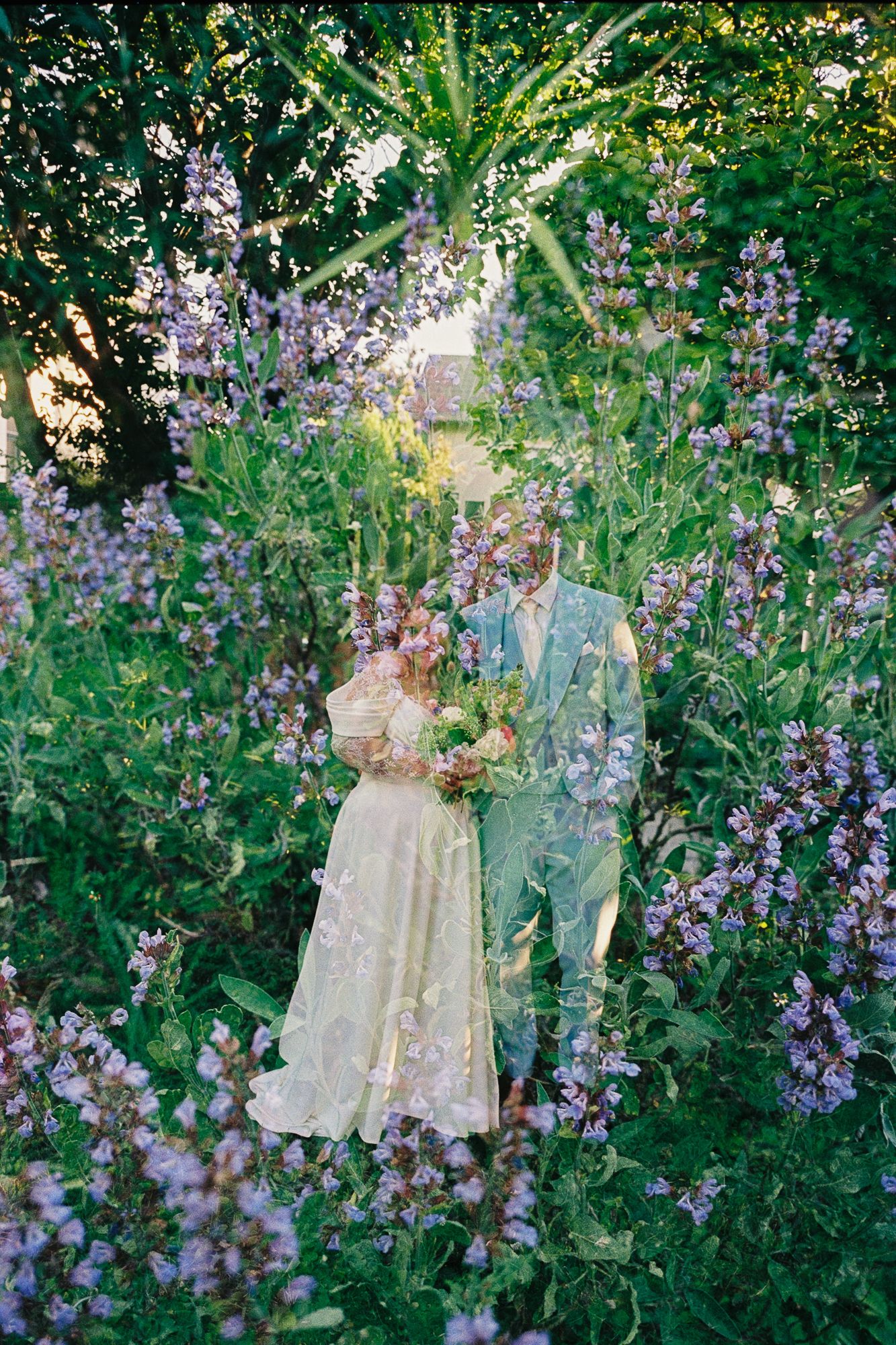 A bride and groom stand surrounded by blooming lavender and wildflowers in a lush garden, captured in a dreamy double exposure.