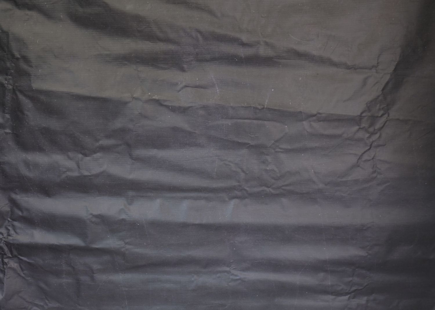 Gray wrinkled paper texture background with creased surface.