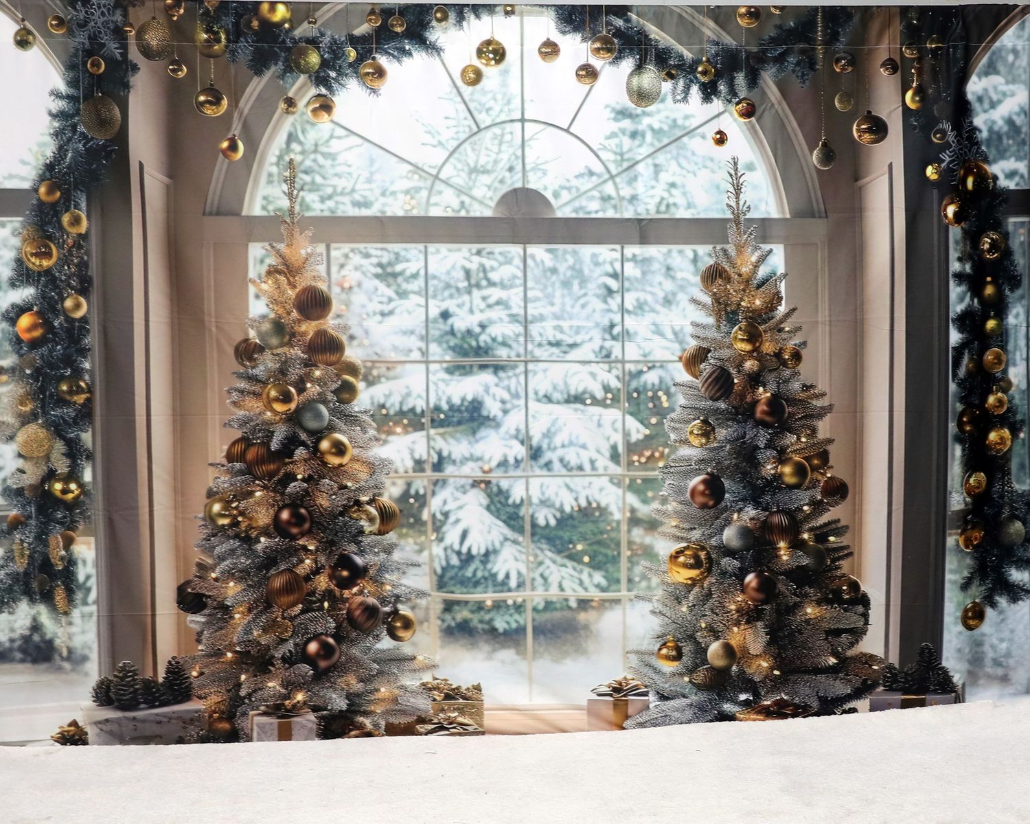 Luxurious Christmas window display with gold ornaments and two decorated trees framing a snowy mountain view.