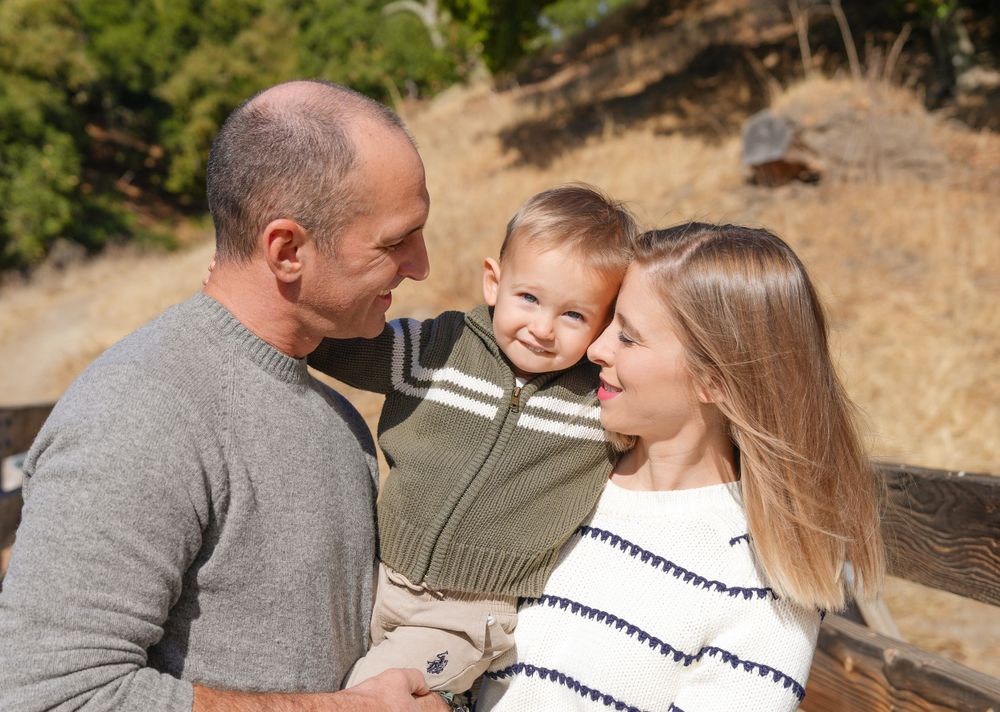 A joyful family shares an intimate moment together in a natural outdoor setting.