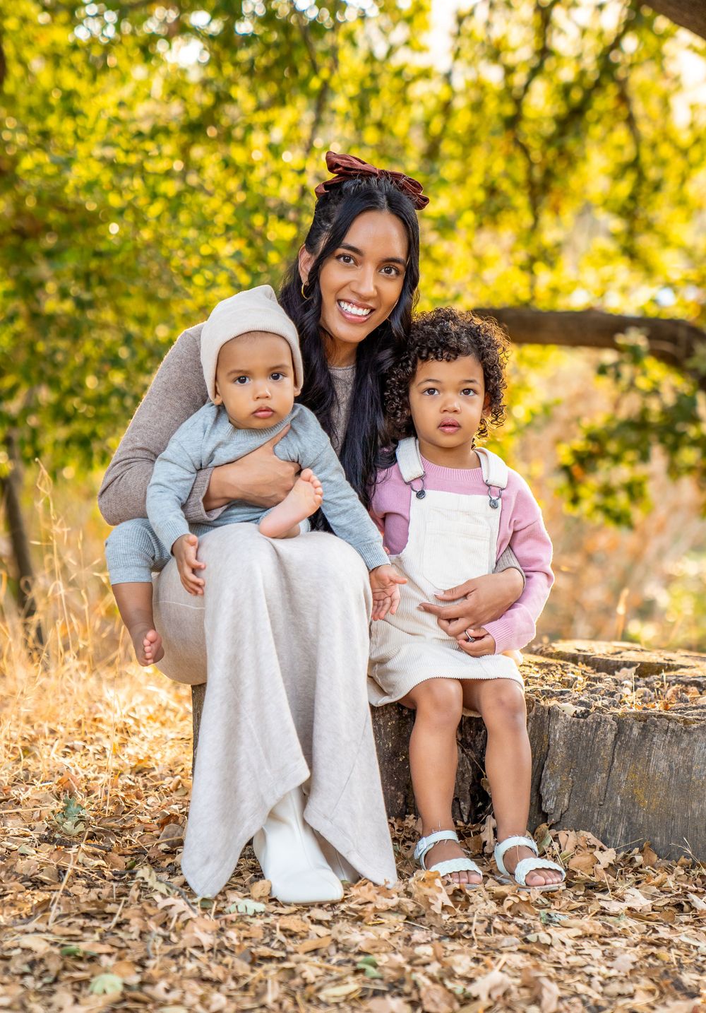 A beautiful autumn family portrait with warm lighting and natural outdoor scenery.