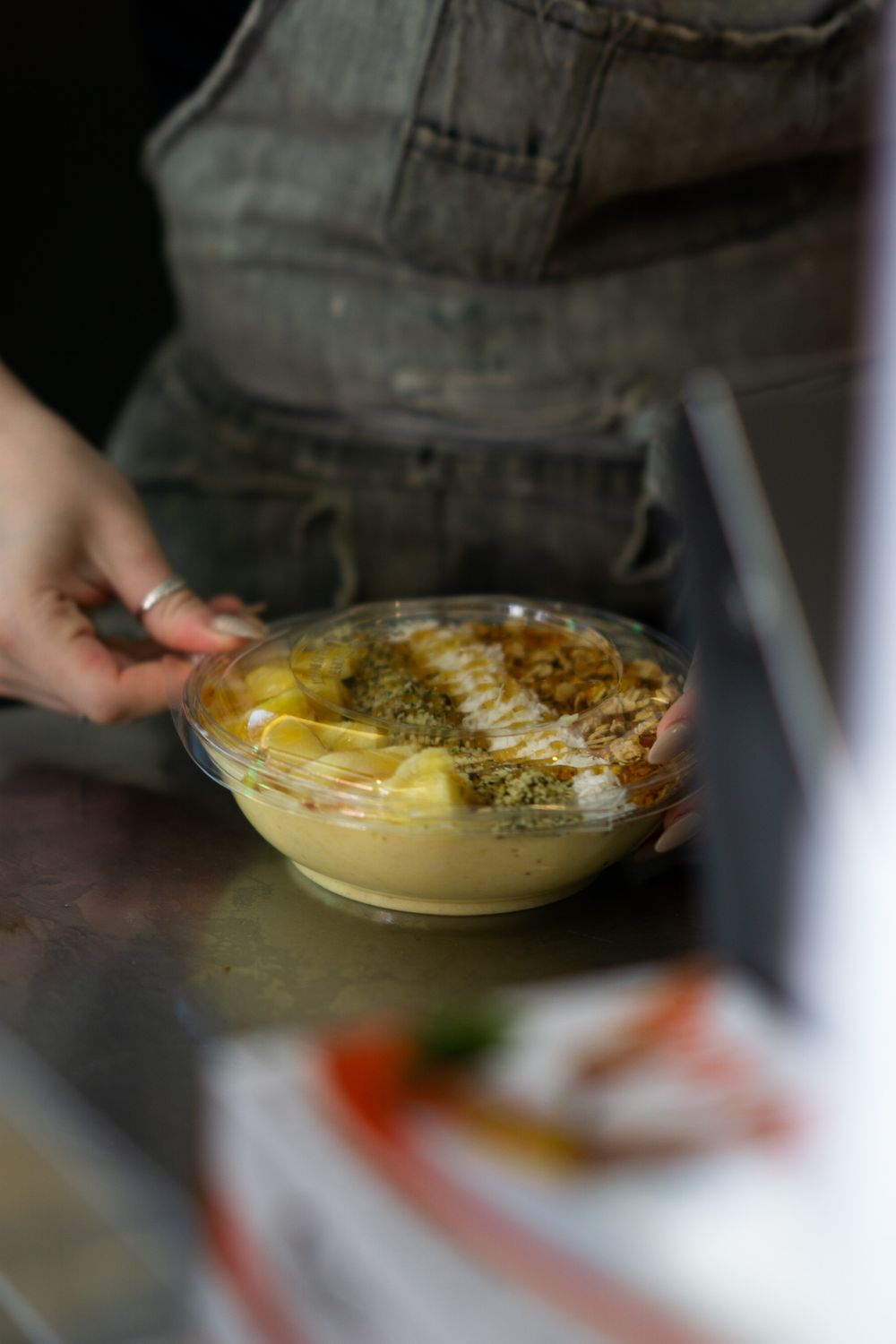 A series of photos showing hands mixing ingredients in a clear glass bowl to prepare a dish.