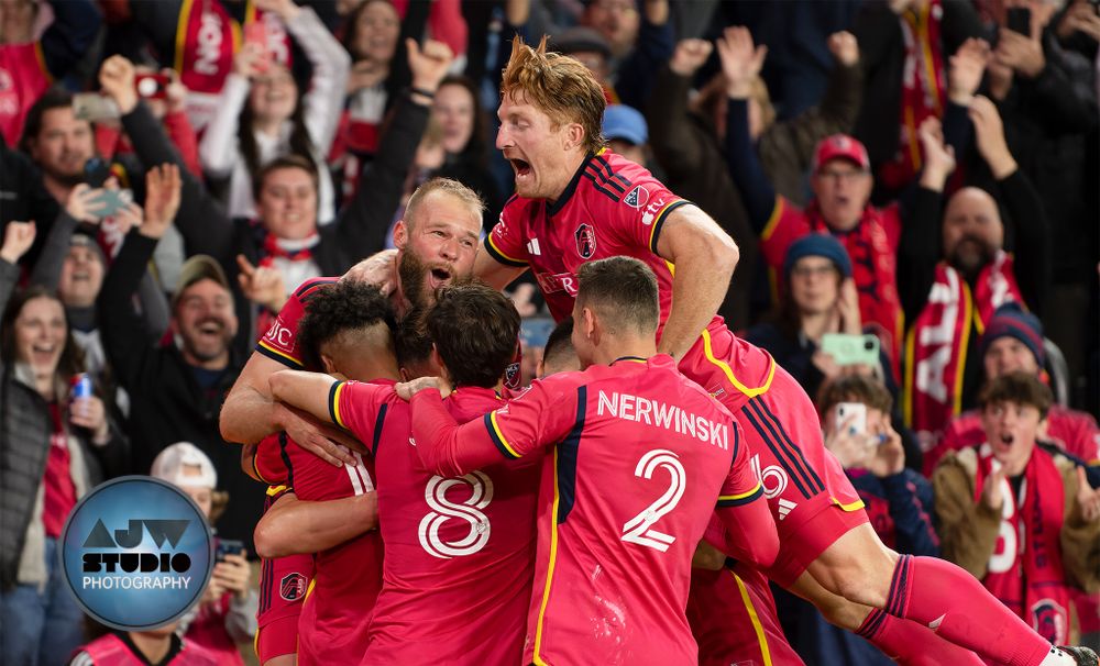 MLS Soccer team celebrates together in a group huddle after scoring a goal.