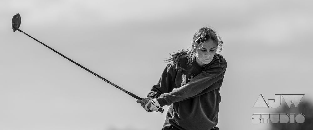 Black and white profile shot of golf swing in action.
