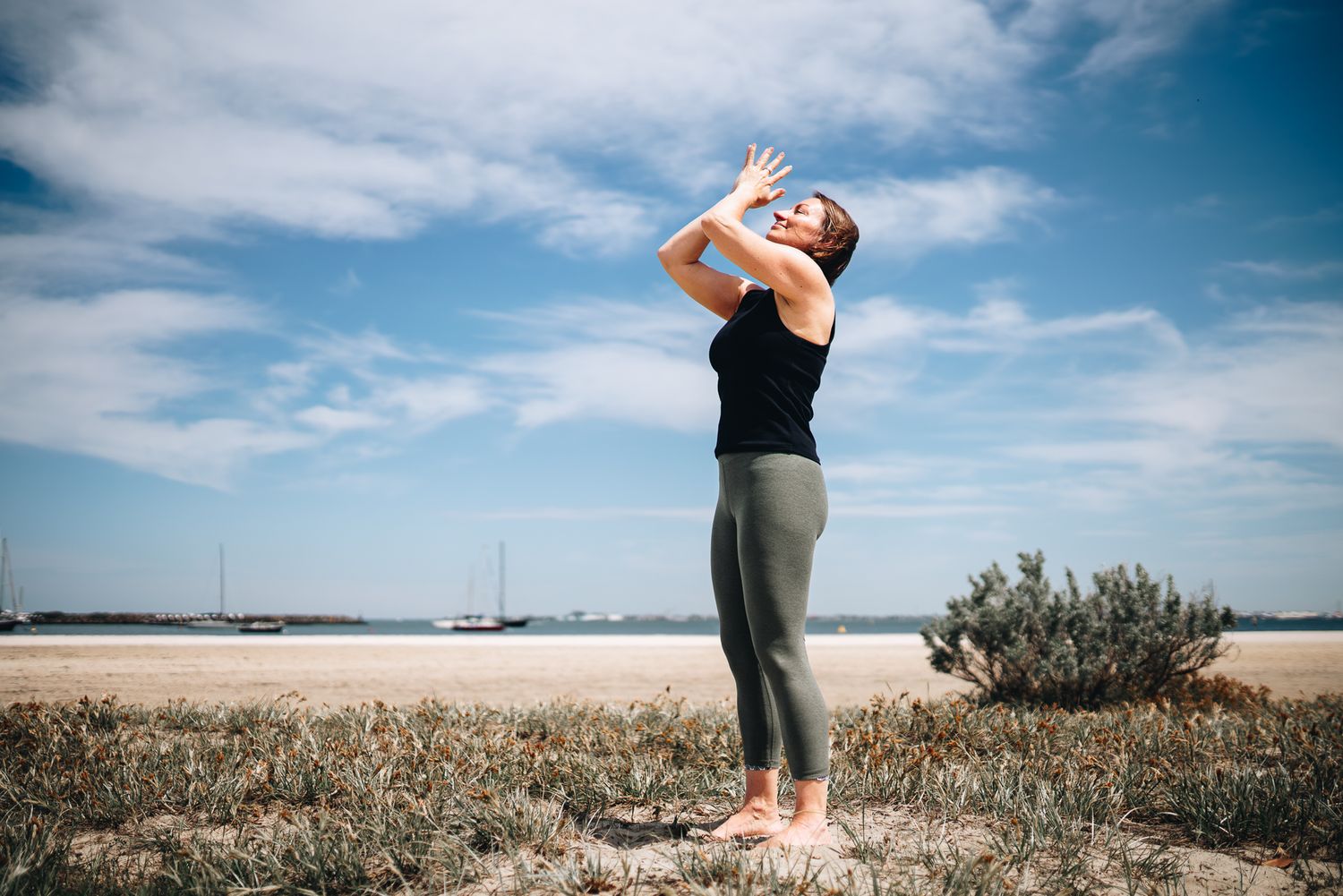 Yoga and qigong instructor doing stretches in an outdoor beach professional branding photo session with a Melbourne branding Photographer