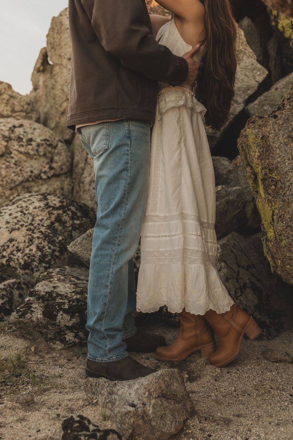 Close-up shots of a couple's feet and legs as they stand together near rocky terrain.
