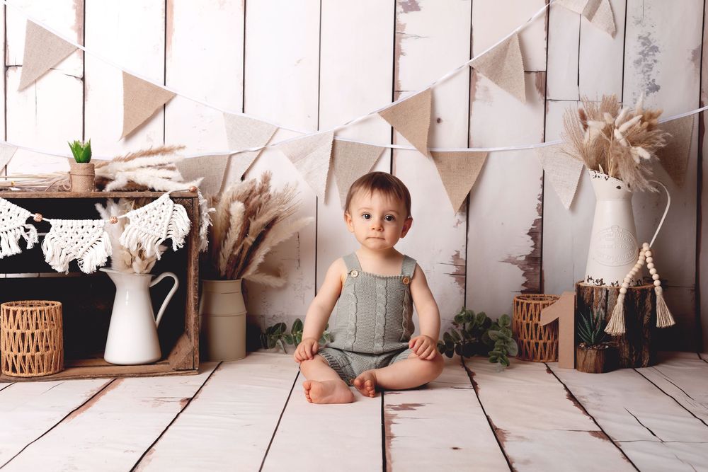 Rustic white wooden backdrop with neutral bunting, vintage decor elements and soft decorative accents.