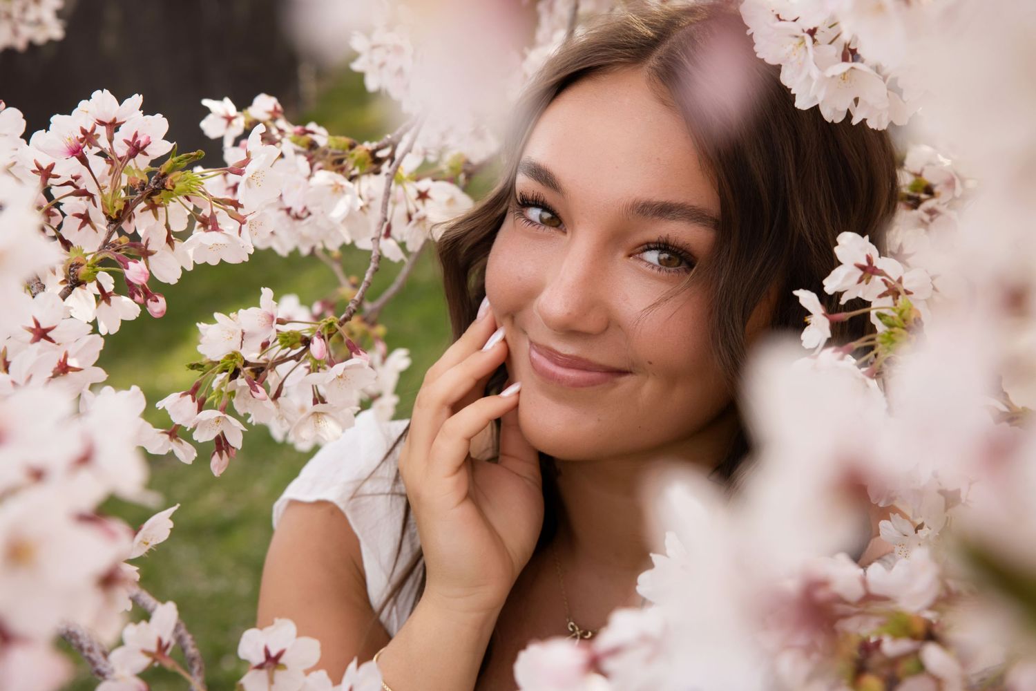 Salt Lake City Senior Photographer - A portrait outdoors among delicate pink cherry blossoms with soft natural lighting and bokeh effect.