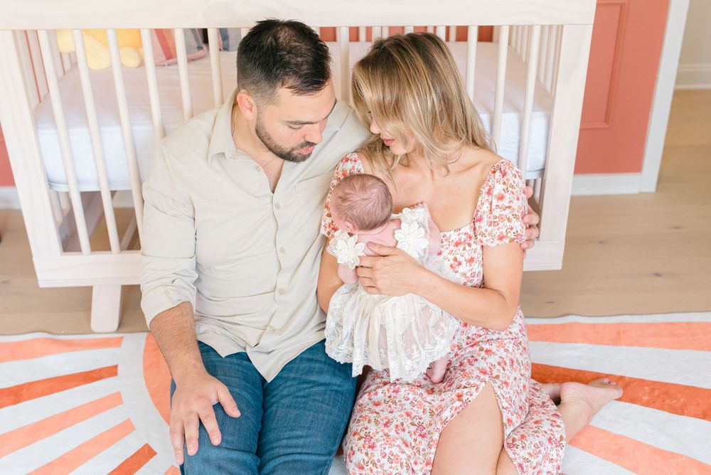 An overhead shot of a new family sitting in the nursery during an in home newborn photo session in Monmouth County nj.