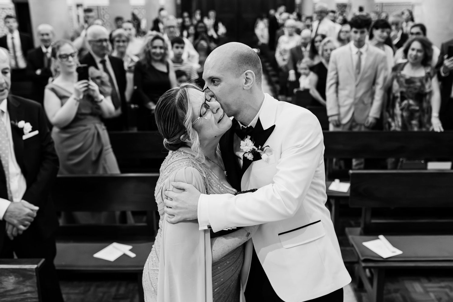 Black and white photo of groom and mother together at the altar on wedding day in lisbon