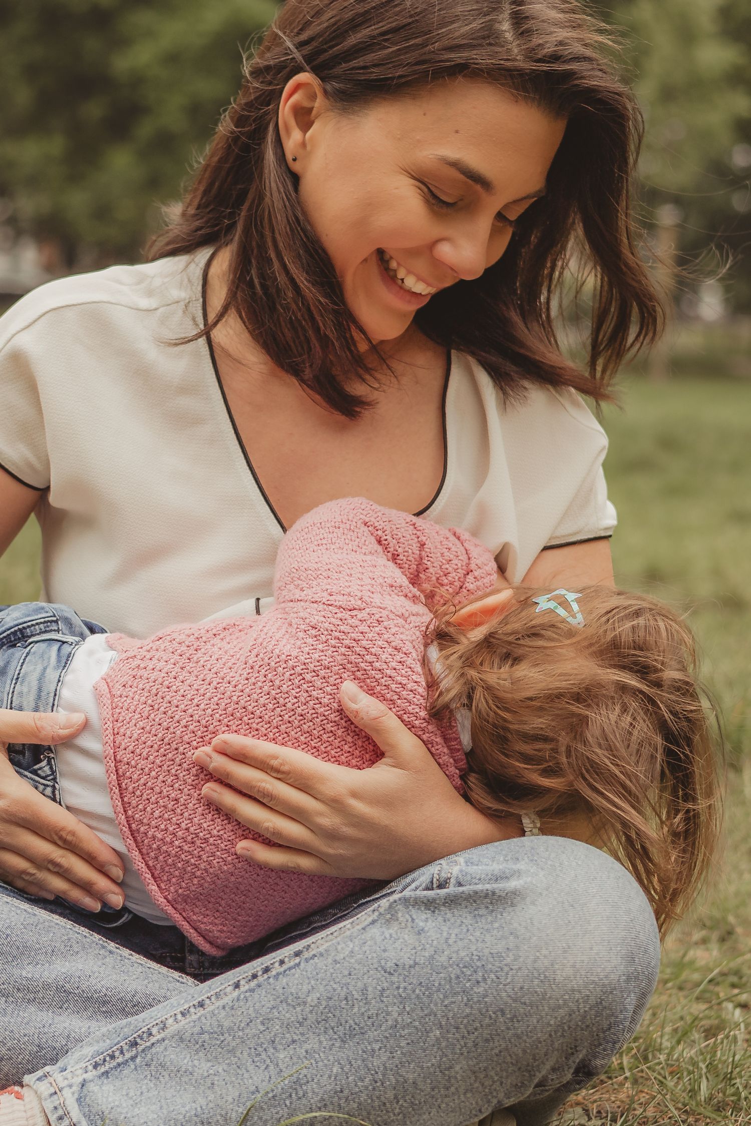 mum breastfeeding toddler outdoors on tooting common