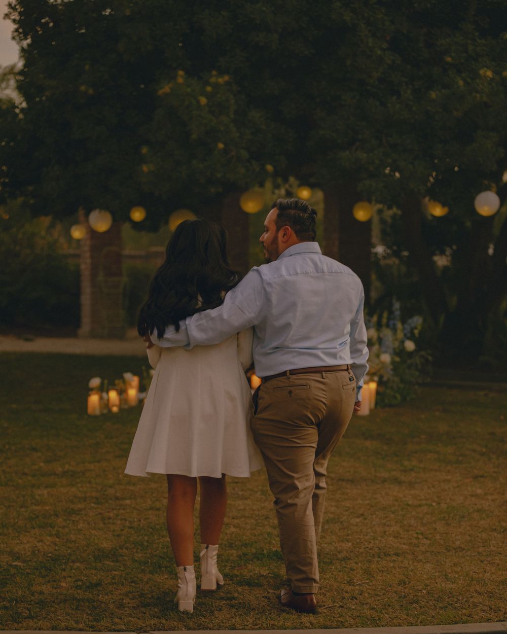Photograph of couple arm in arm walking towards a romantic picnic for their surprise proposal near Los Angeles.