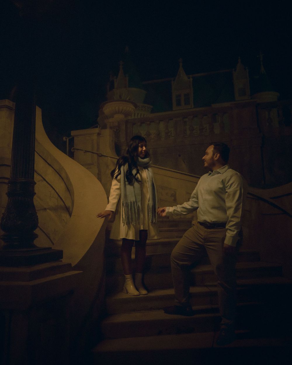 Romantic couple hand in hand walking down a castle like staircase at the Kimberly Crest House and Gardens.