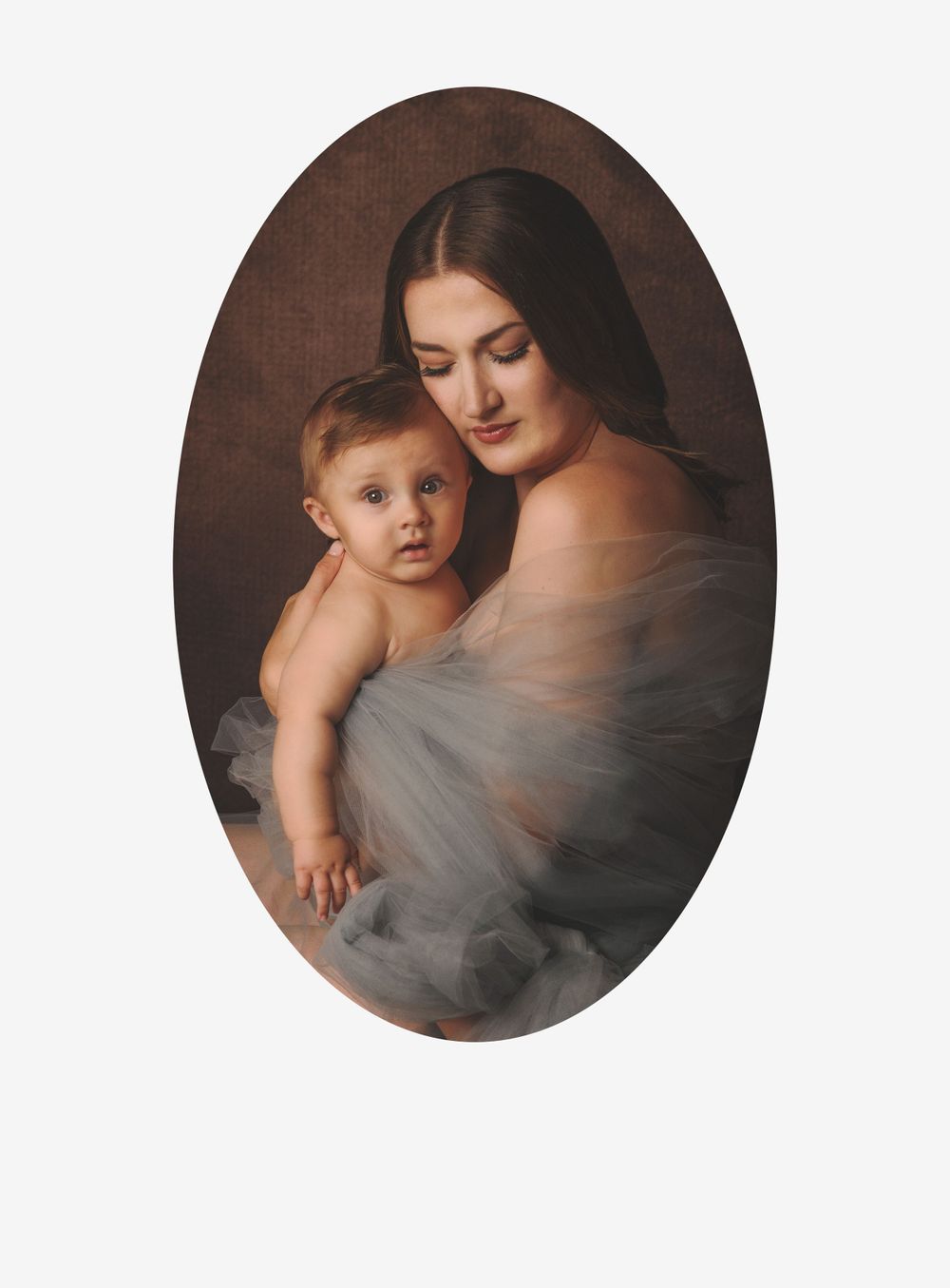 Portrait depicting a tender moment between parent and child in muted tones with soft lighting and flowing gray fabric.