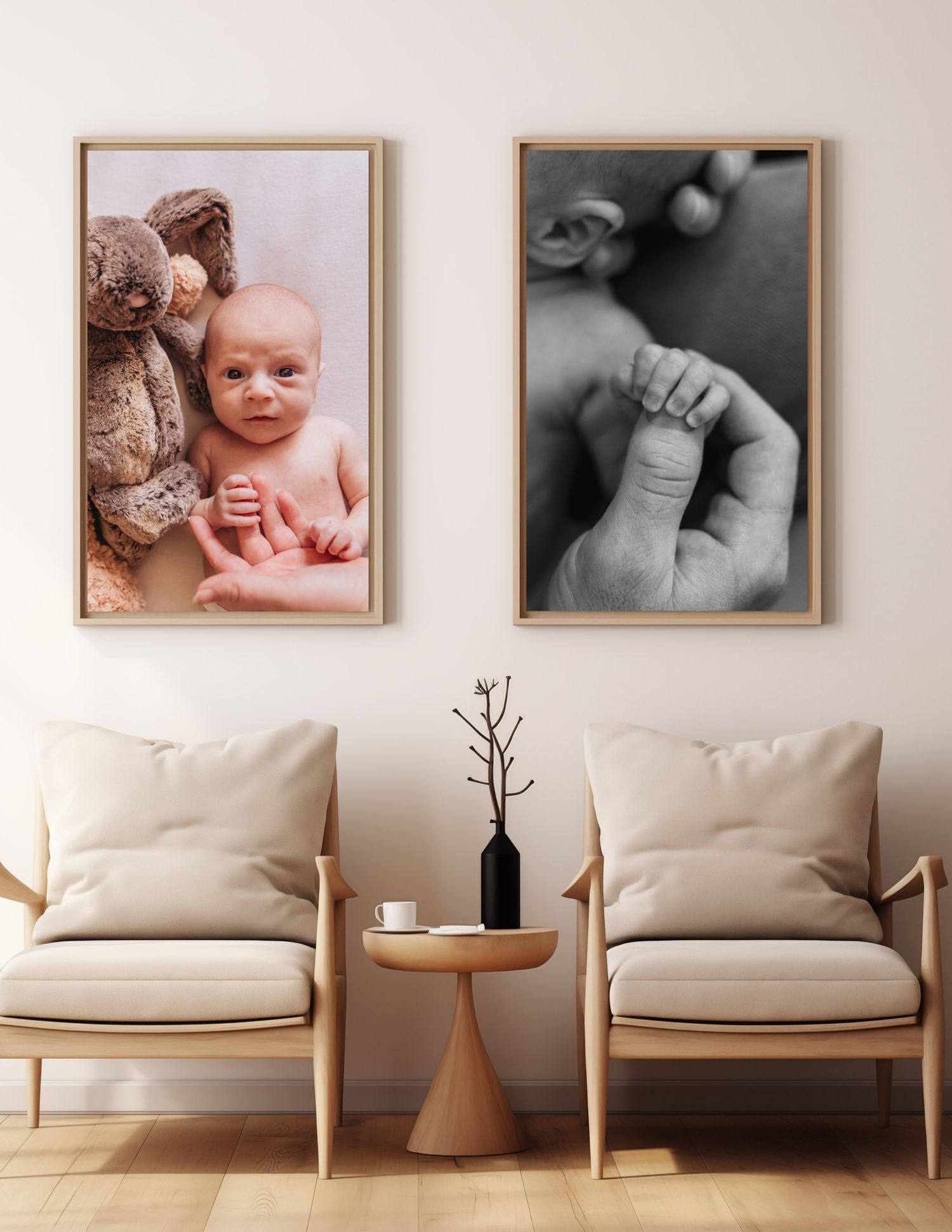 Modern living room decor with two framed photographs displayed above beige armchairs and a small wooden side table.