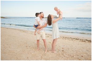 Happy family enjoying a beach sunset moment together on sandy shore with ocean waves in background.