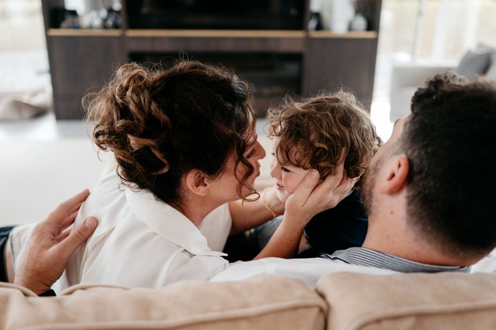 Intimate family moment shared on couch showing affection and connection.