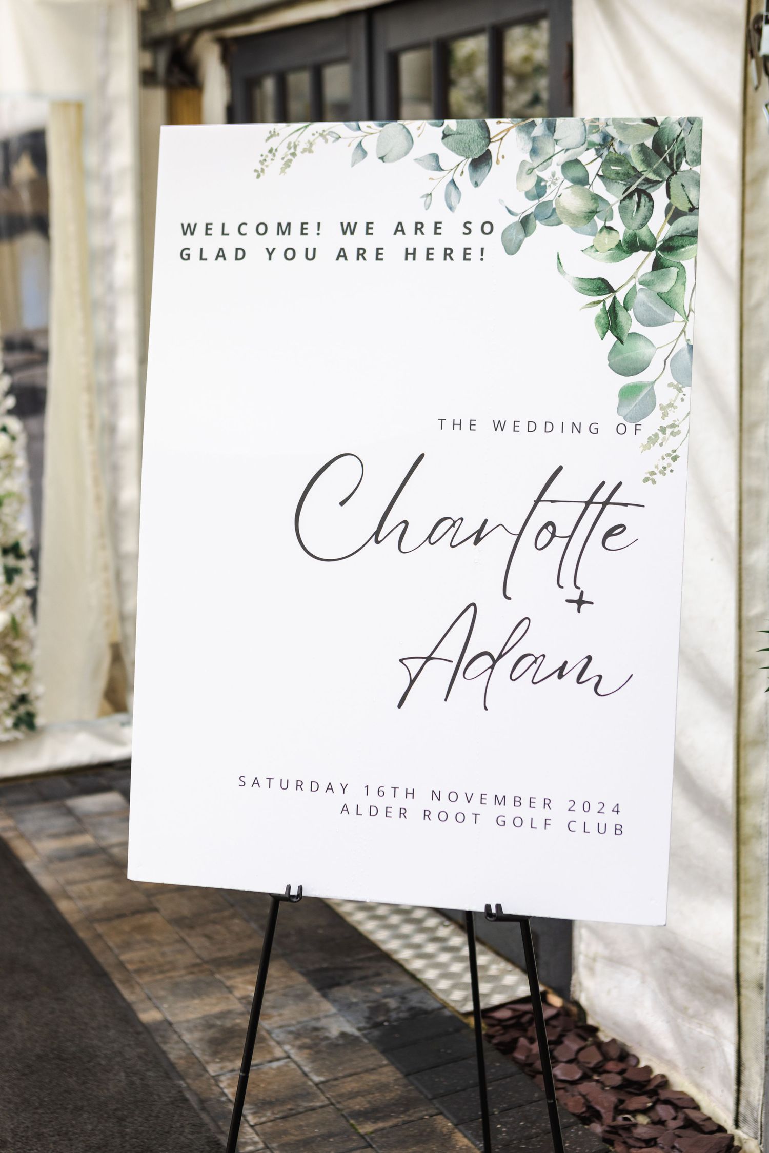 Elegant wedding welcome signs with eucalyptus decorations and calligraphy text.