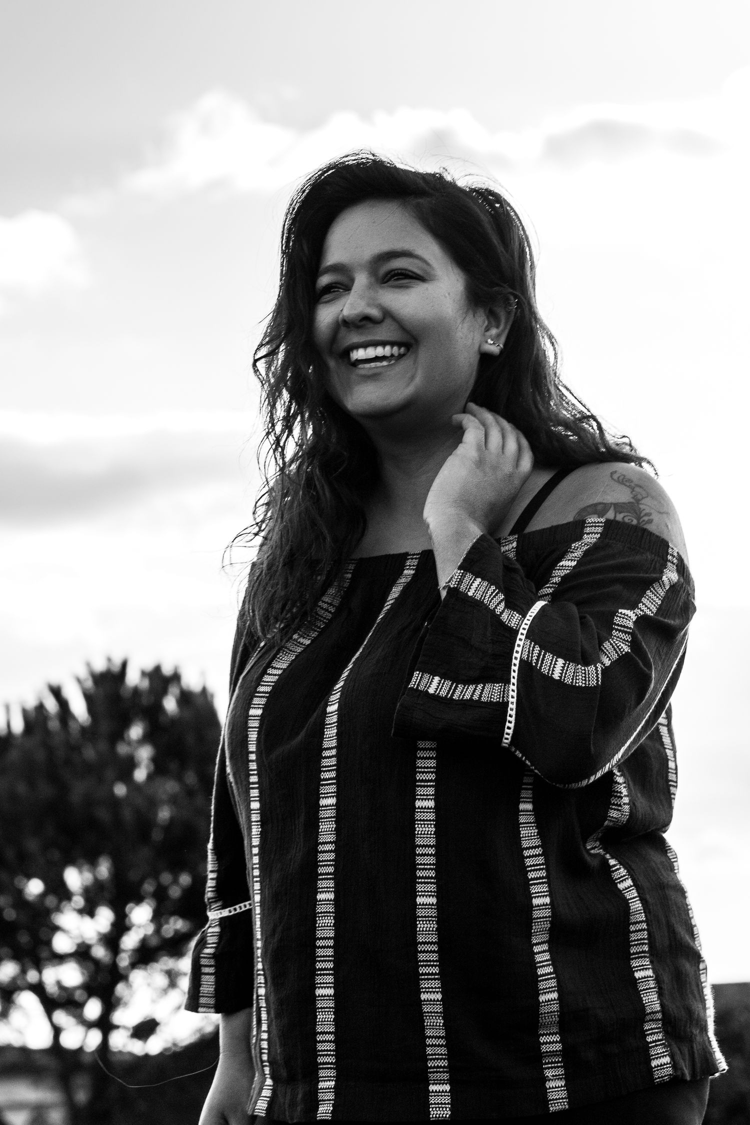 Woman in black and white smiling into distance on Maui