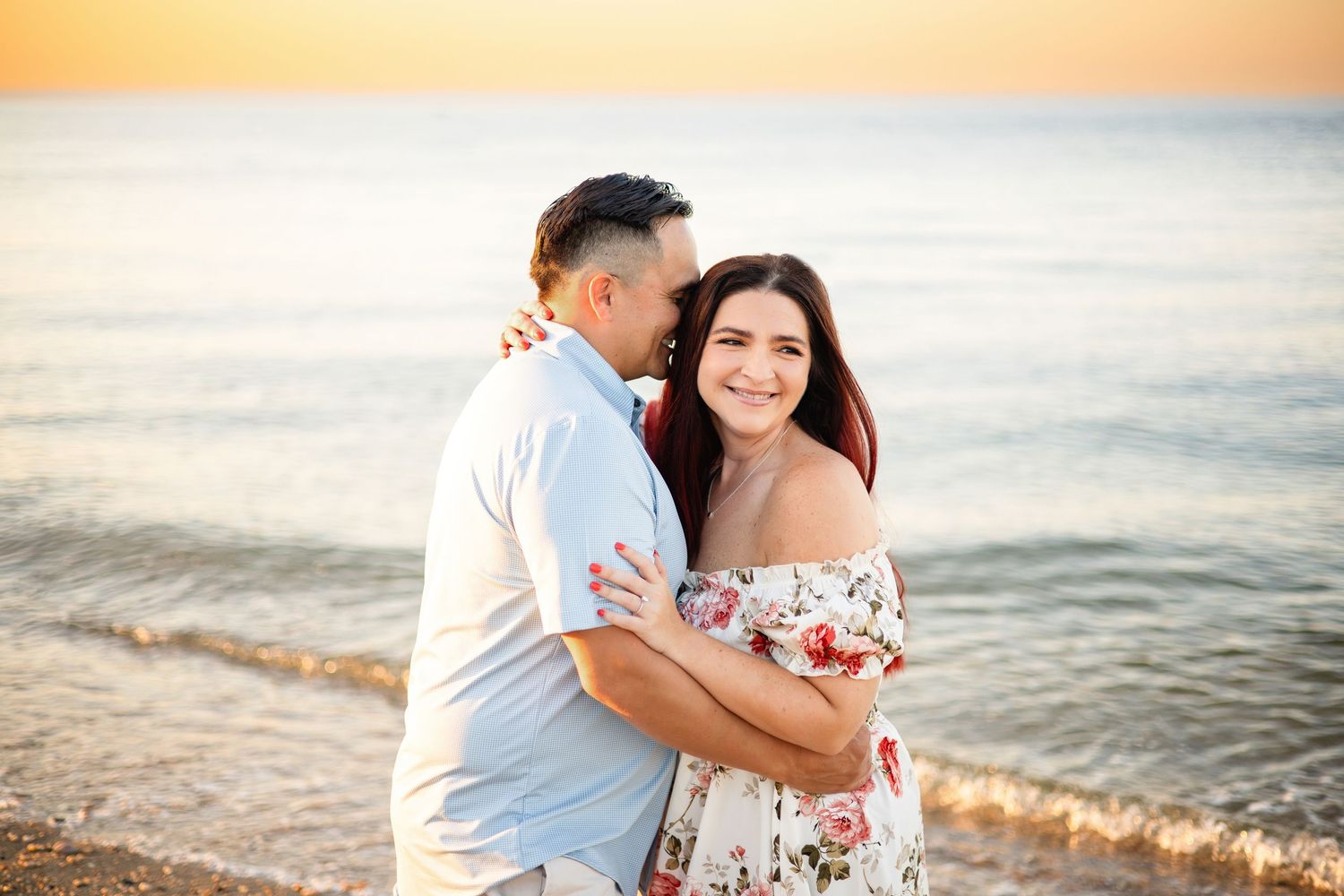 A romantic proposal scene set between rows of grapevines in a scenic vineyard with white flowers and a blanket.