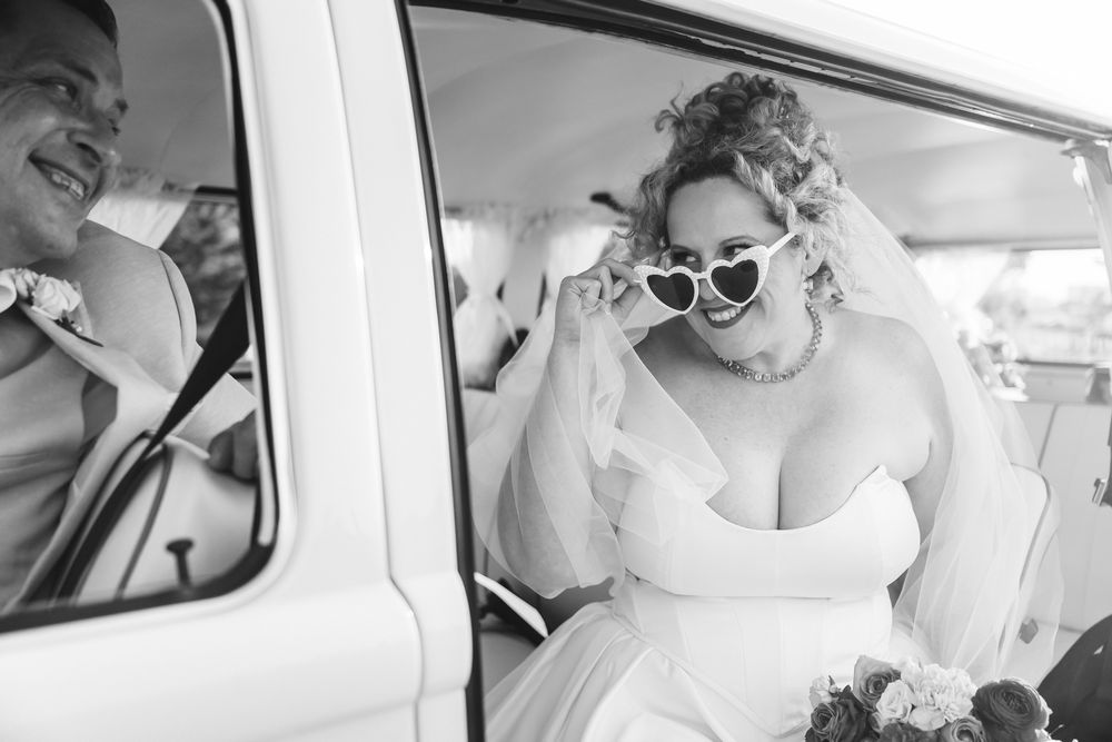 A collection of black and white wedding photos showing joyful moments inside and around a vintage car.