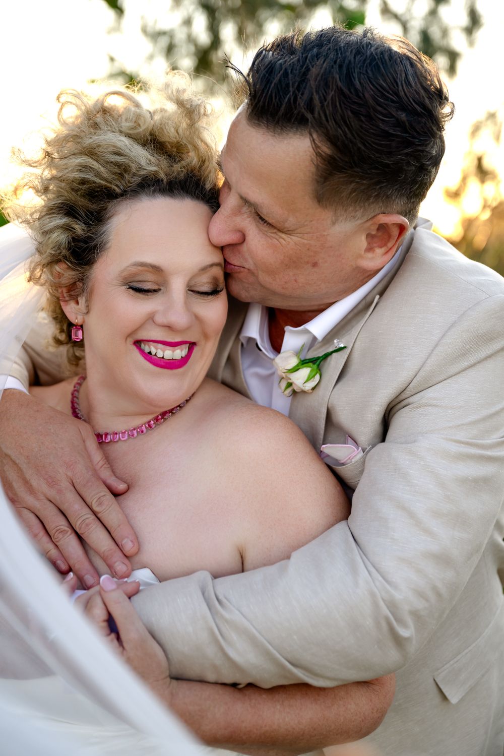 Romantic wedding couple shares intimate moments in a series of tender embraces against a soft natural backdrop.