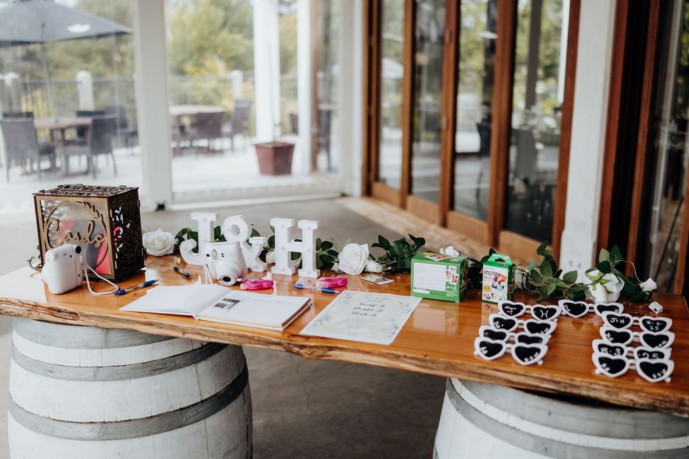 Wedding reception table setup with wooden details and black party favors.